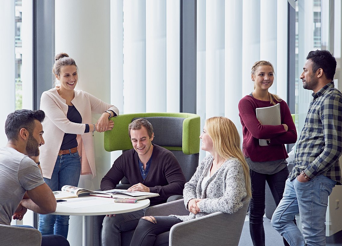 Eine Gruppe Studierender lernt gemeinsam und unterhält sich miteinander