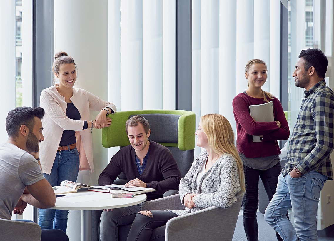 Eine Gruppe Studierender lernt gemeinsam und unterhält sich miteinander